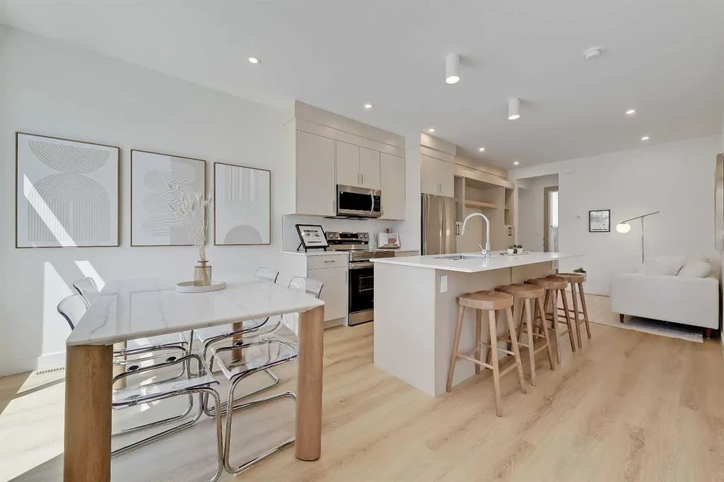 Open-concept main floor showing dining table, kitchen island, and living room in a Renfrew Urban Multi-level Home