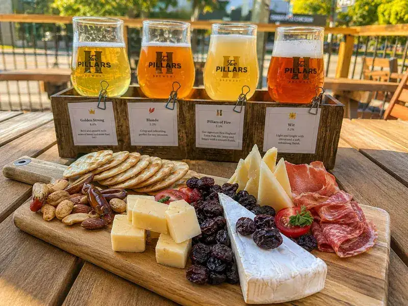 Brewery patio in Bridgeland with a beer flight and charcuterie board on a sunny summer afternoon